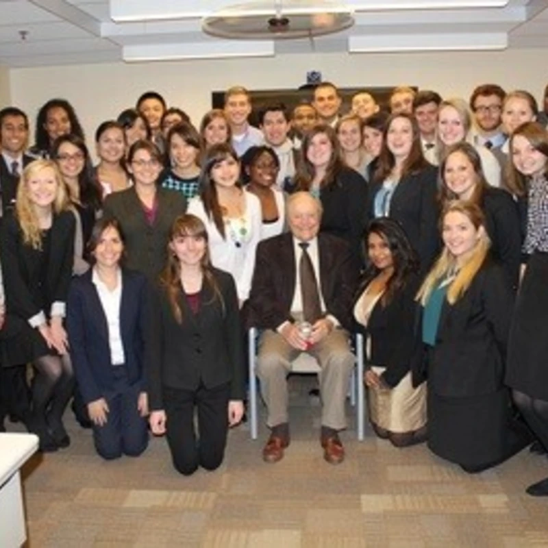 A group of Archer Fellow alumni gathered around founder Bill Archer.