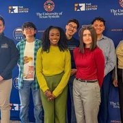A group of Archer Fellows stand together in front of an Archer Center backdrop.