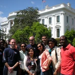 A group of people pose in front of the White House
