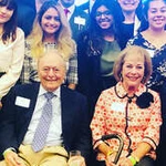 Bill and Sharon Archer sit in front of a group of smiling Archer Fellows.
