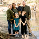 Erin Doherty and Ray Mitchel pose with family near a river.