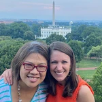 Katie Romano poses, smiling with a friend, the White House and Washington Monument in the distat background