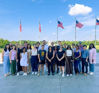 Summer 2025 Graduate Archer Fellows in front of U.S. Flags